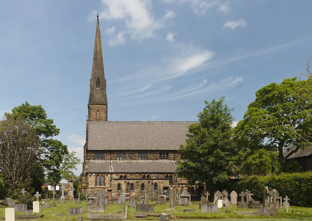 The south side of Grade II listed Ss Mary &amp; John church, Newton-le-Willows across the churchyard.