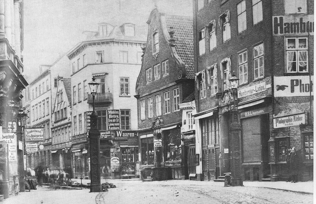 View of Nobistor, one of the border crossings between Hamburg and Holsatian/Prussian Altona, marked by one cast iron lantern post on each side of the carriageway. Behind them Reichenstrasse leading west to Grosse Bergstrasse. The sign "Waaren" is at the junction of Grosse Freiheit from the right (north).
